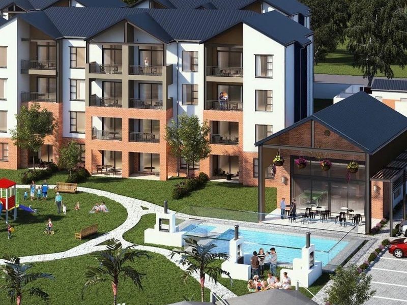 Aerial view of a modern apartment complex featuring a swimming pool, clubhouse, landscaped communal gardens, and covered parking facilities.