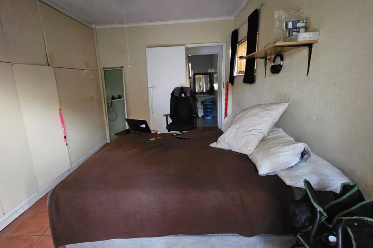 A bedroom featuring built-in cupboards and tiled flooring, requiring cosmetic updates to improve the overall finish and appeal.