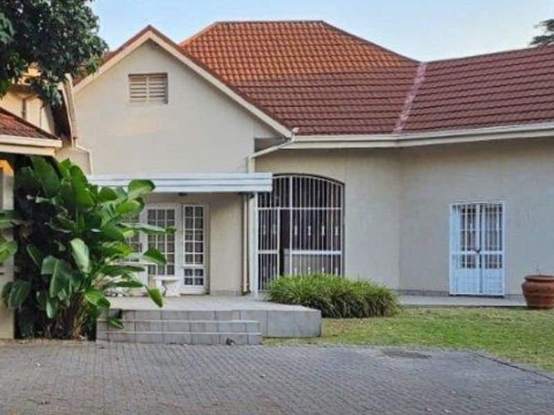Front elevation of a single-story house featuring a tiled roof, paved driveway, and security-fitted windows and doors.