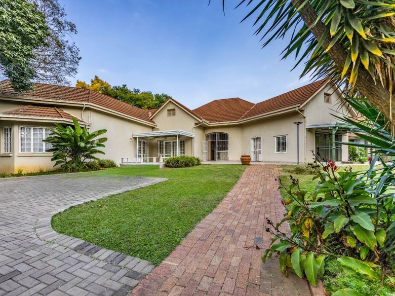 A well-maintained single-story residence featuring a tiled roof, brick-paved driveway, and a landscaped front garden with secure access points.