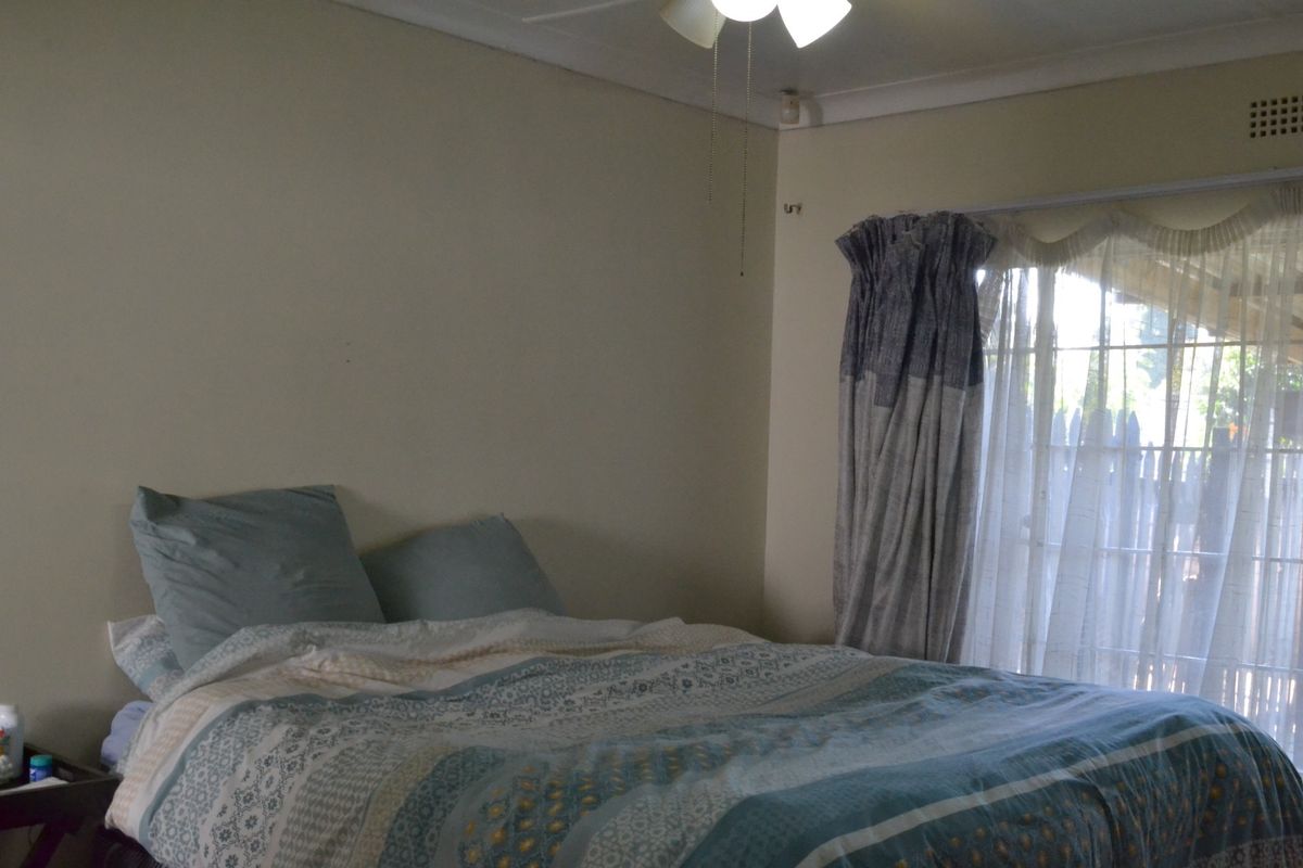A bedroom featuring a ceiling fan and a sliding glass door providing natural light and access to the exterior.