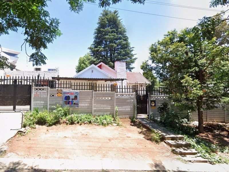 Front view of a residential property featuring a precast concrete boundary wall, metal security gate, and a tiled roof structure.