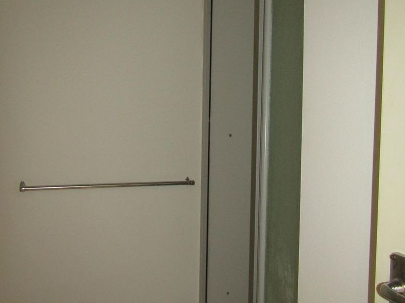 A compact bathroom featuring a shower enclosure with a glass door and a wall-mounted towel rail.