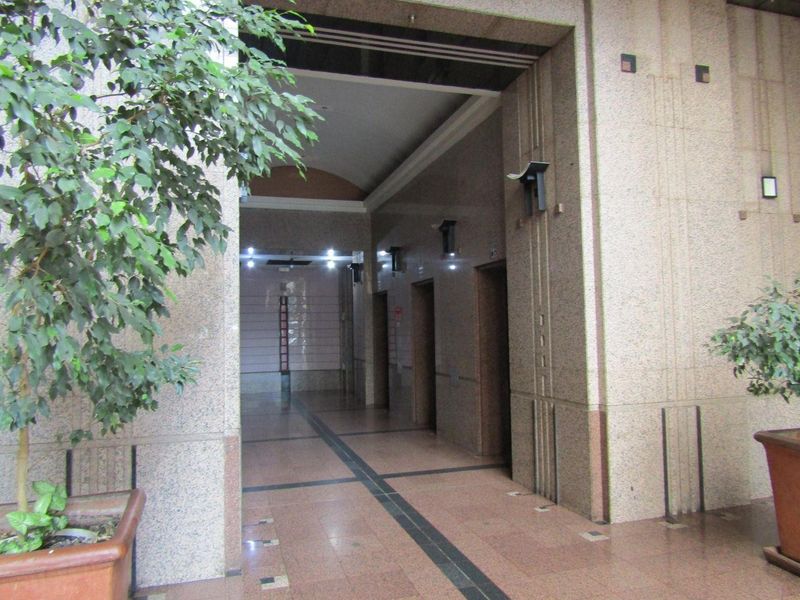 A formal apartment building entrance lobby featuring polished granite wall and floor finishes with a dedicated elevator bank.