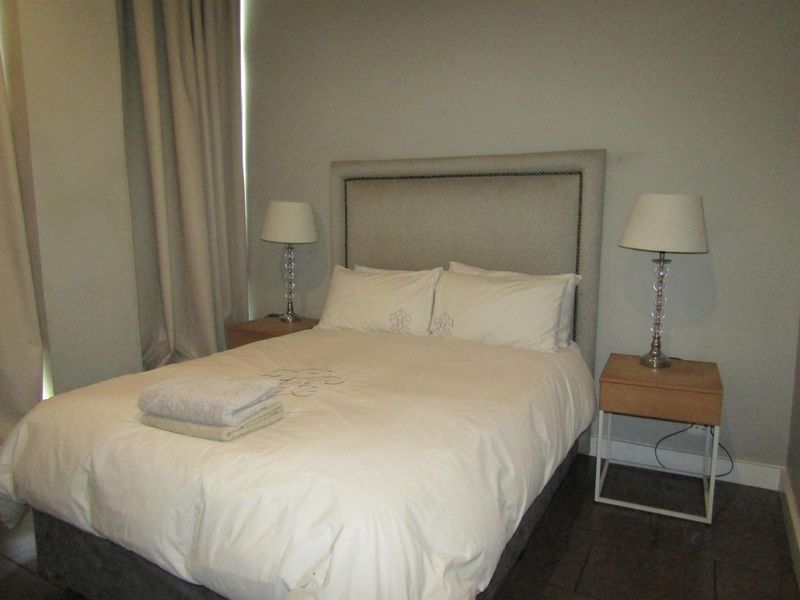 A bedroom featuring tiled flooring and neutral wall finishes, providing a functional space for rest.