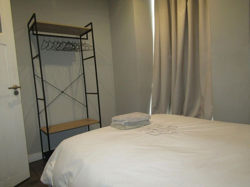 A functional bedroom featuring neutral wall tones, laminate flooring, and a standard internal door, providing a clean and simple living space.