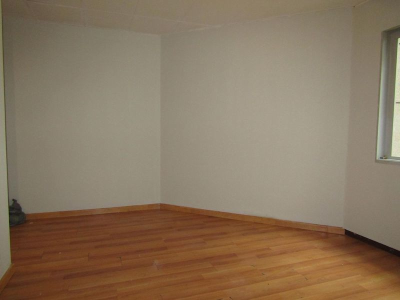 An empty bedroom featuring laminate flooring and neutral walls, providing a blank canvas for personalization.