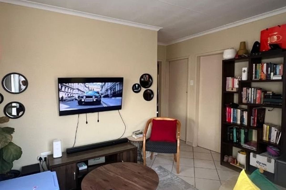 A comfortable living room featuring tiled flooring and coved ceilings, providing a functional and neutral space for relaxation.