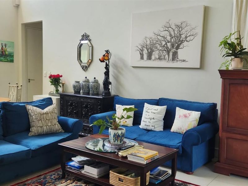 Spacious open-plan living area featuring tiled floors, high ceilings, and an integrated kitchen space, offering a versatile layout for comfortable daily living.