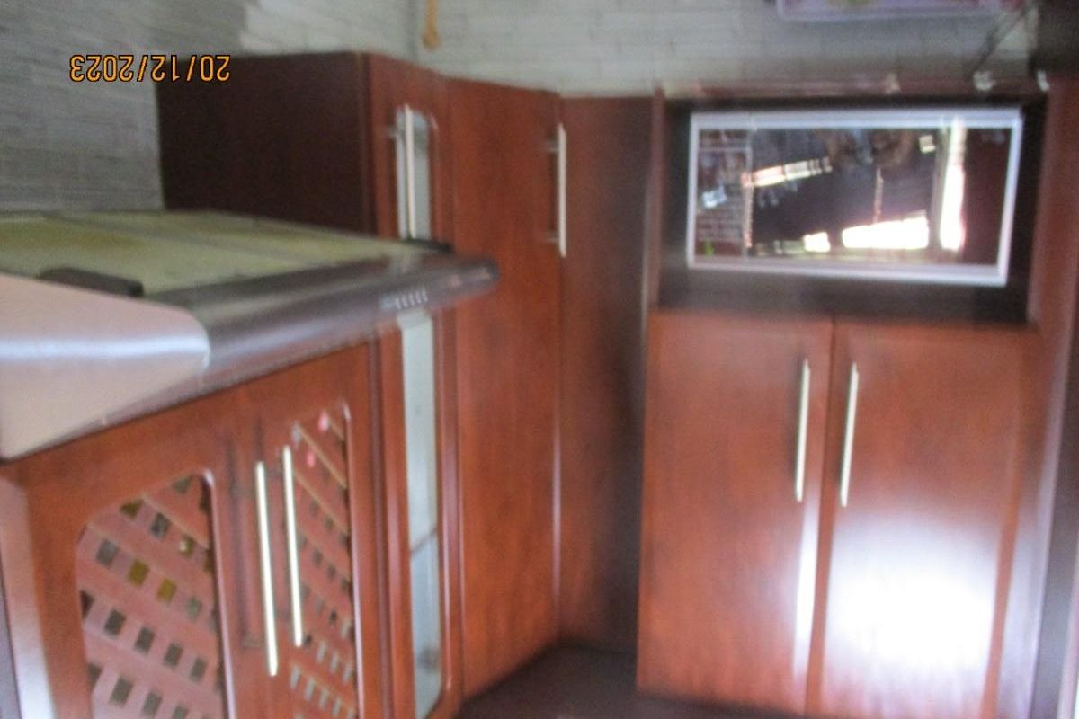 A kitchen area featuring dark wood cabinetry, built-in microwave, and integrated extractor fan.