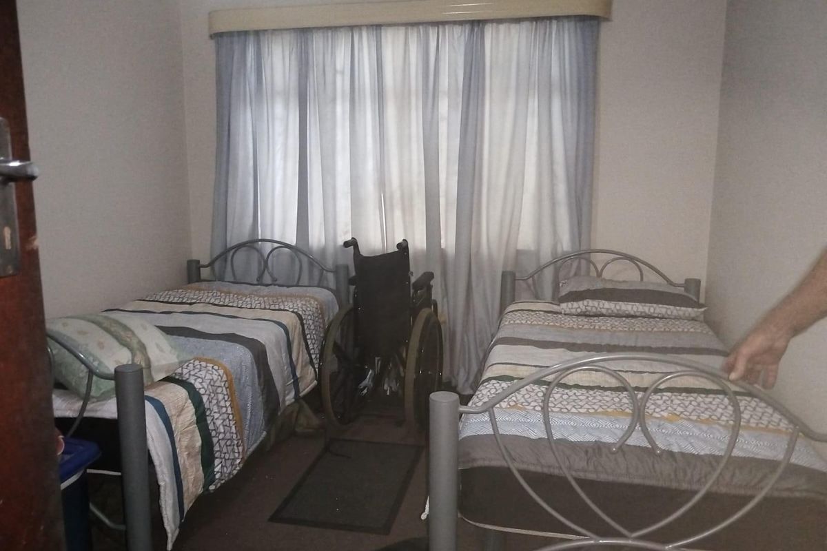 A bedroom featuring neutral walls and a window with curtain pelmet.