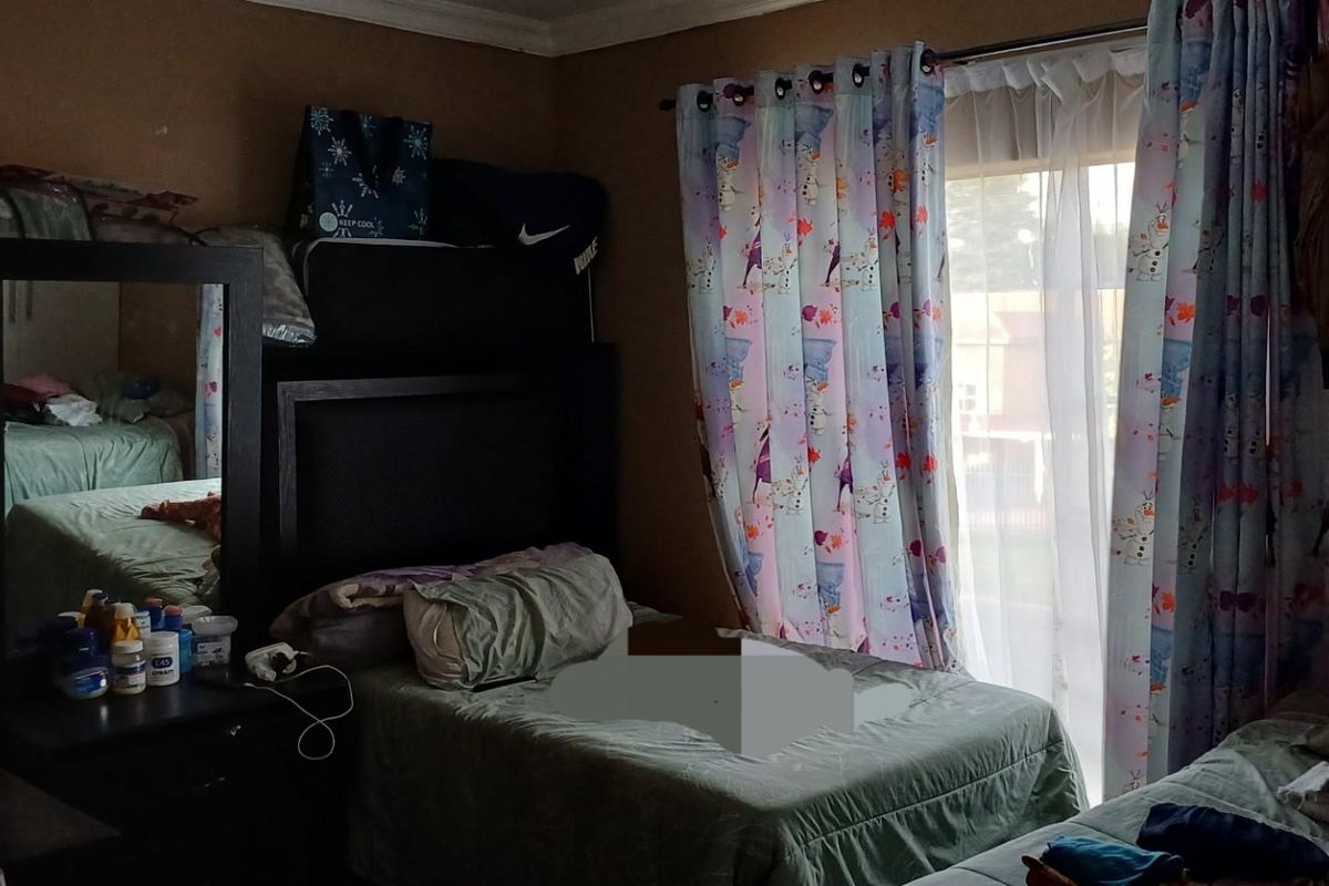 A bedroom featuring a sliding glass door with curtain treatments and standard interior finishes.
