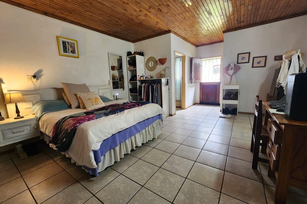 Spacious bedroom featuring tiled flooring, a timber-clad ceiling, and direct access to an exterior door.