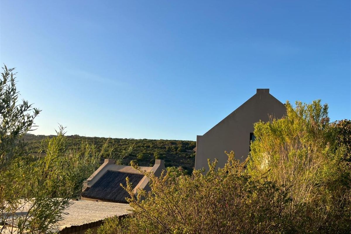 A view of the farm property featuring traditional gabled architecture and thatched roofing set against a natural landscape.