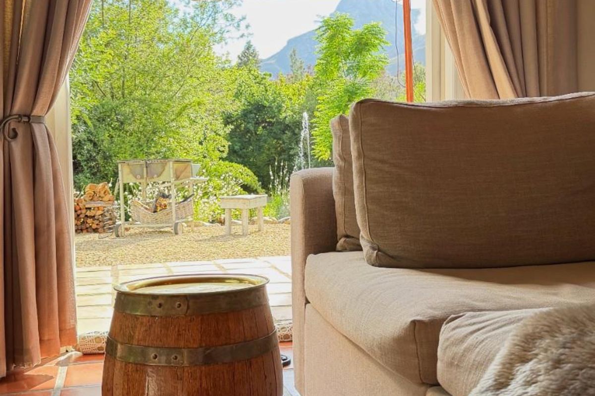 A view from an interior living space looking out through glass doors onto a private garden patio area.