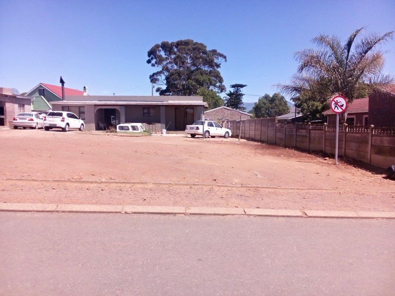 A view of a residential property from the street, featuring an unpaved front yard area and a single-story dwelling.