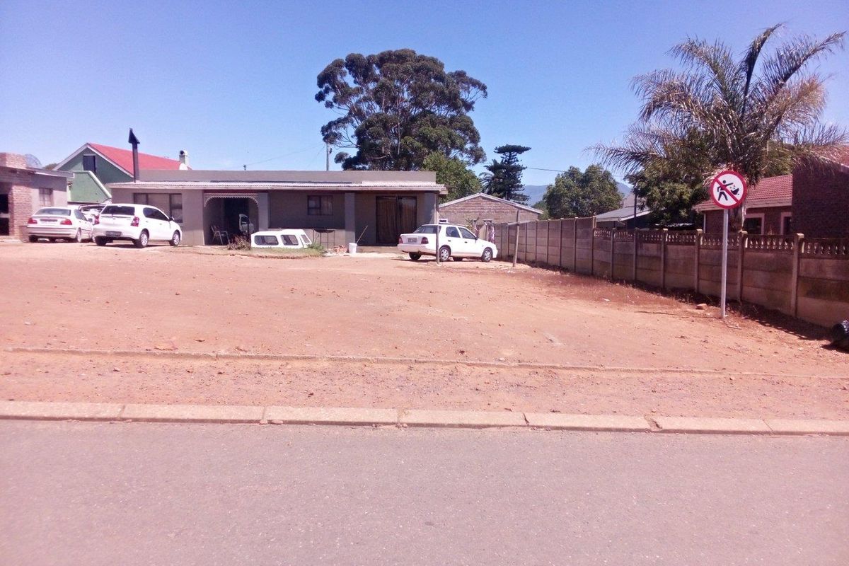 A view of a residential property from the street, featuring an unpaved front yard area and a single-story dwelling.