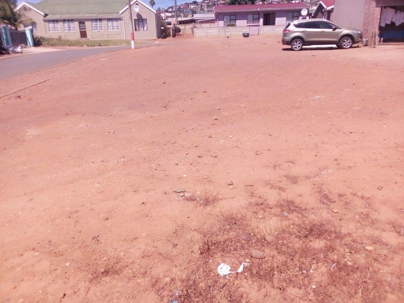A vacant residential plot of land featuring an open, level surface, situated in an established neighborhood with surrounding residential properties.