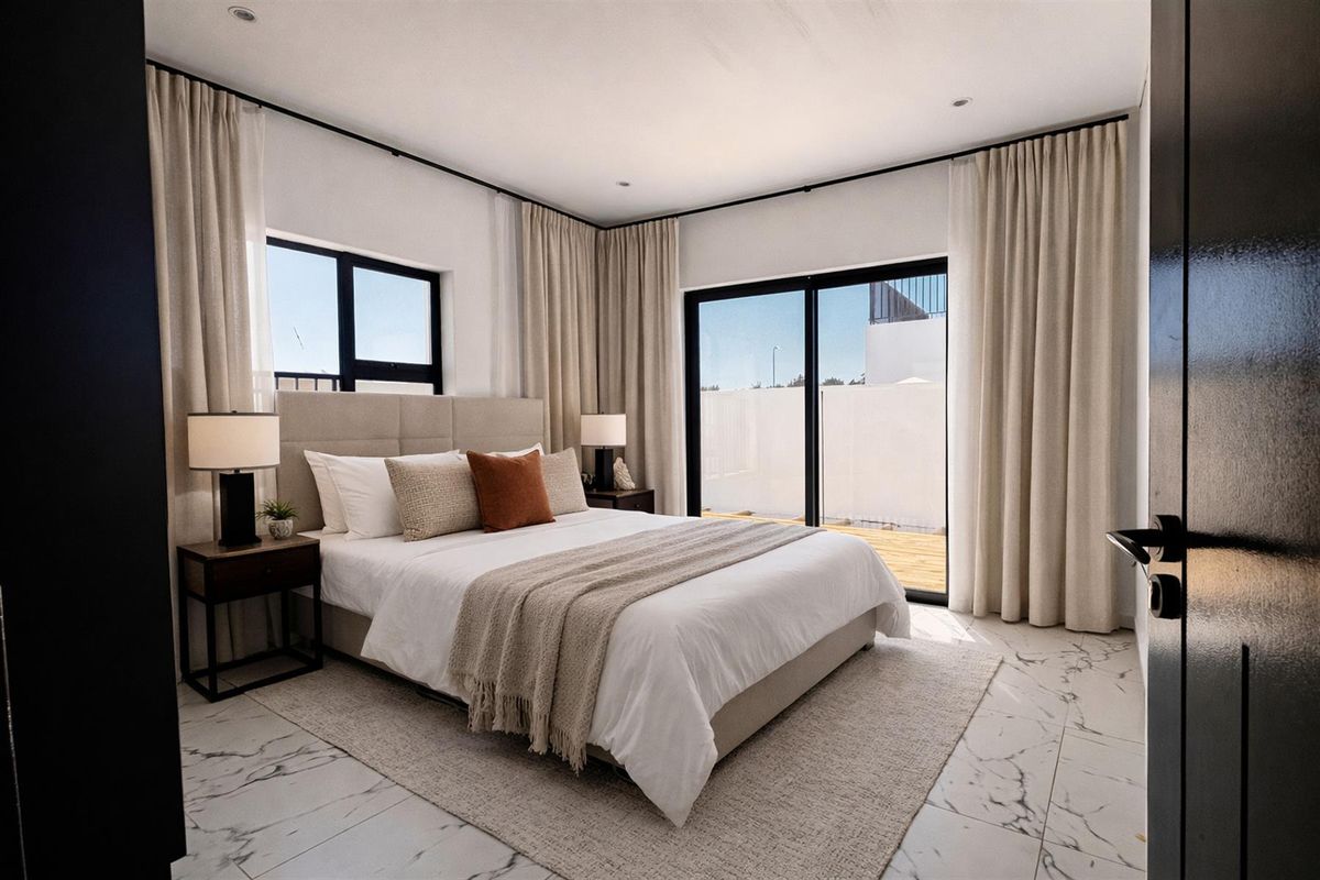 Modern bedroom featuring marble-look tiled flooring, large sliding glass doors leading to an outdoor area, and recessed ceiling lighting.