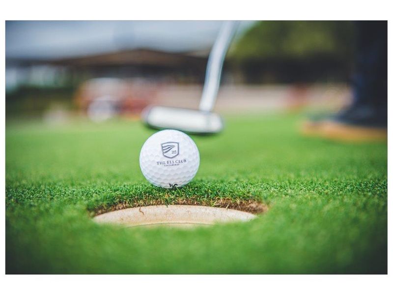 A close-up view of a golf ball on a putting green at a golf course facility.
