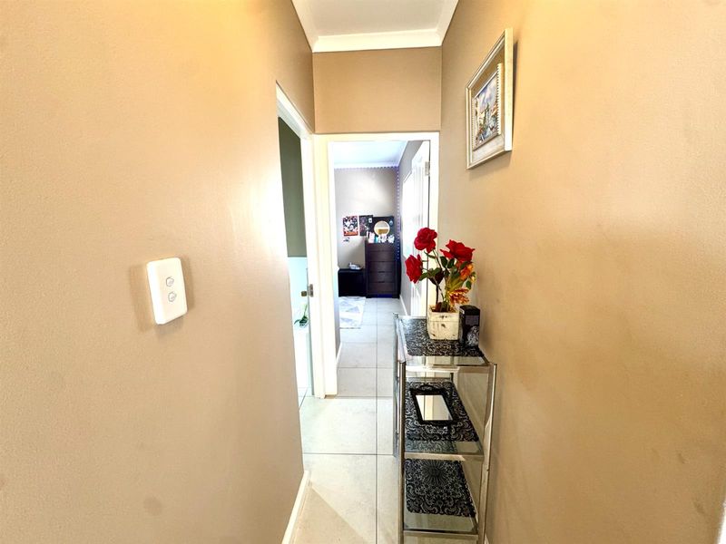 A functional hallway featuring tiled flooring and neutral wall tones, providing access to adjacent rooms within the home.