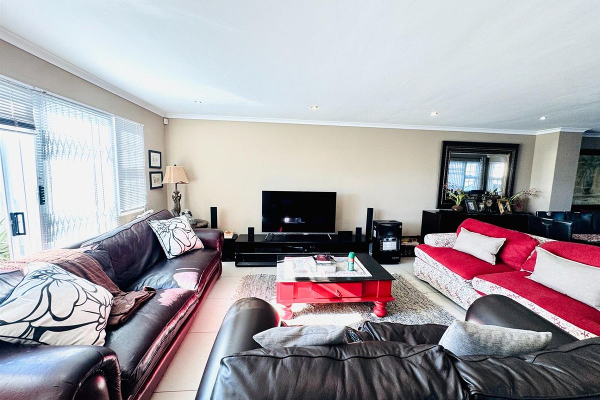 Spacious living room featuring tiled flooring, recessed ceiling lighting, and large sliding glass doors providing access to the outdoor area.