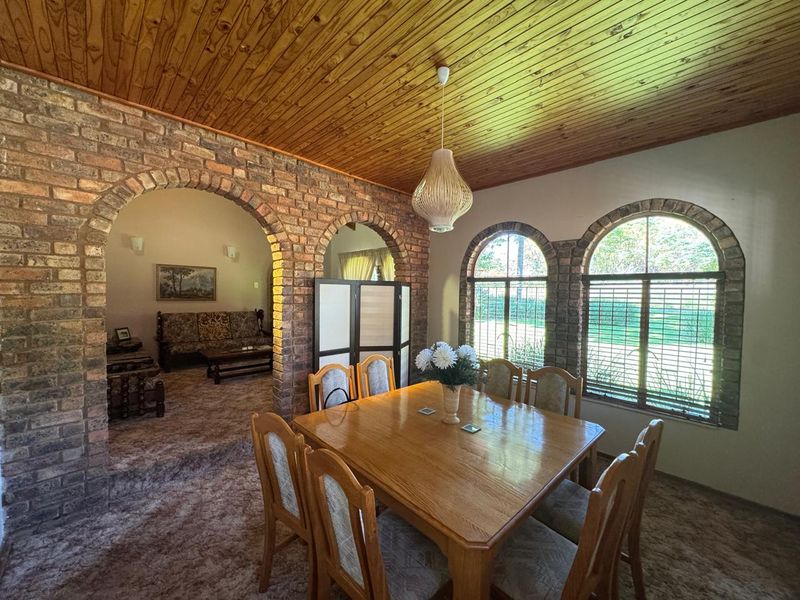 Dining area featuring exposed brick archways, timber ceiling, and arched windows, offering a rustic aesthetic with potential for modern updates.