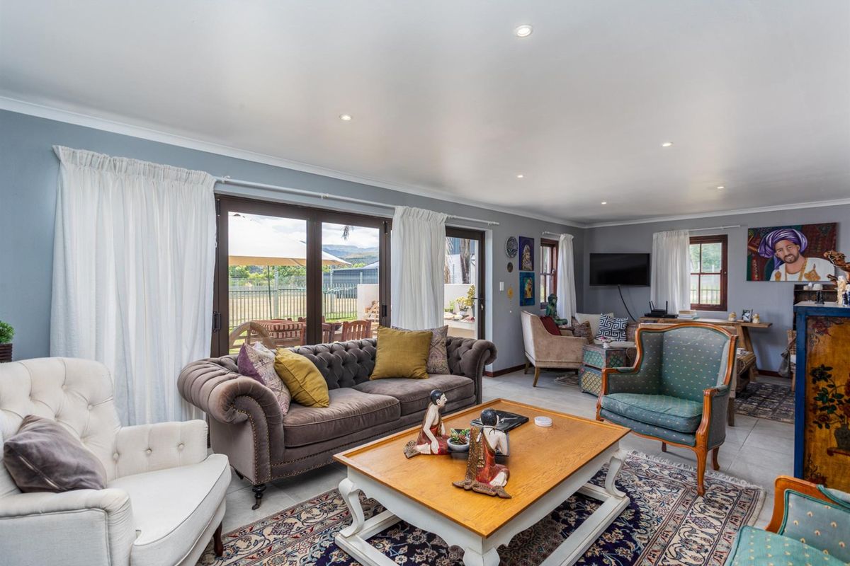 Spacious living room featuring tiled flooring, recessed downlighting, and large sliding glass doors providing direct access to the outdoor patio area.