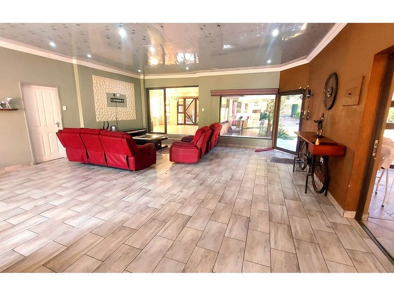 Spacious living room featuring tiled flooring, a textured feature wall, and large sliding glass doors providing natural light and access to the outdoor area.