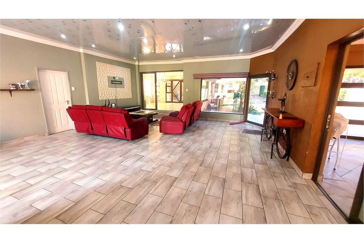 Spacious living room featuring tiled flooring, a textured feature wall, and large sliding glass doors providing natural light and access to the outdoor area.