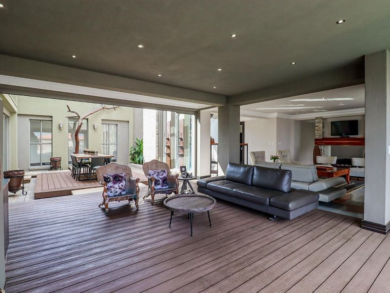 Spacious covered patio featuring composite decking and recessed lighting, seamlessly connecting to the indoor living area through large sliding glass doors.