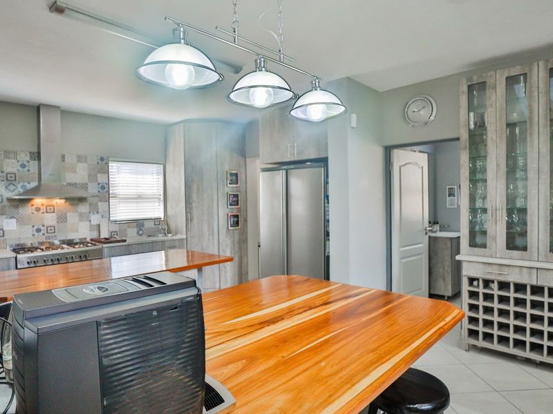 Modern kitchen featuring wooden countertops, built-in cabinetry, a gas stove with extractor fan, and a dedicated wine storage rack.