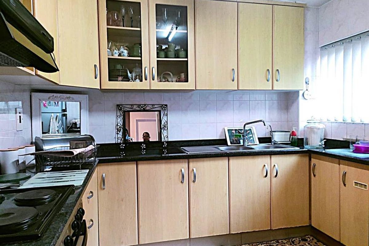 Functional kitchen featuring light wood-finish cabinetry, dark granite countertops, a built-in hob, and an extractor fan with a tiled backsplash.