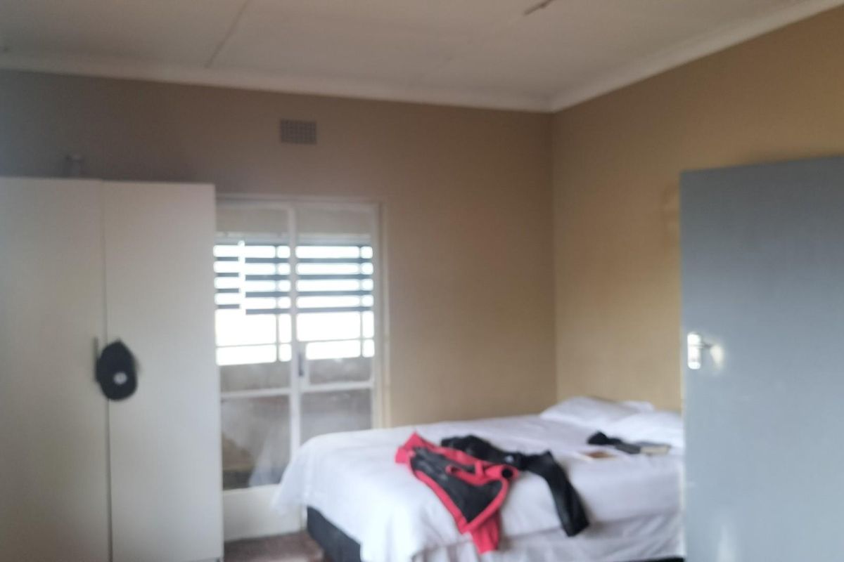 A bedroom featuring neutral wall tones, a built-in wardrobe, and a sliding door providing access to an outdoor area.