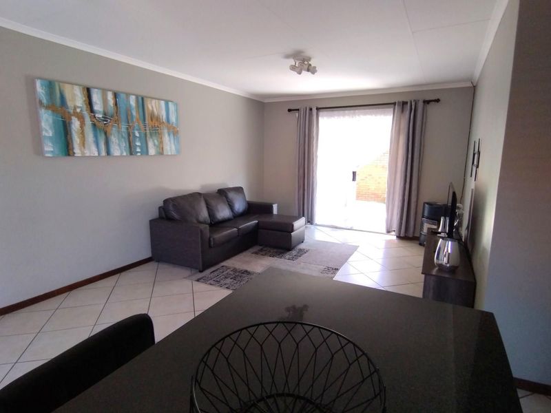 Open plan living area featuring tiled flooring and a sliding glass door providing access to the exterior.