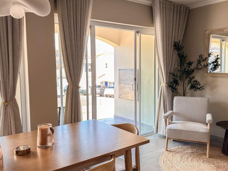 A bright living area featuring large sliding glass doors that provide natural light and direct access to an outdoor patio space.