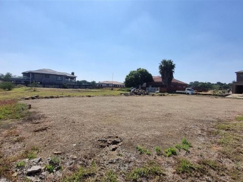 A vacant residential plot of land ready for development, situated in a developed neighbourhood with surrounding residential properties.