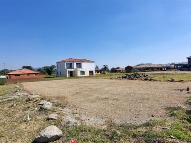 A vacant residential plot situated in a developed estate, featuring street access and utility connection points, ready for new construction.