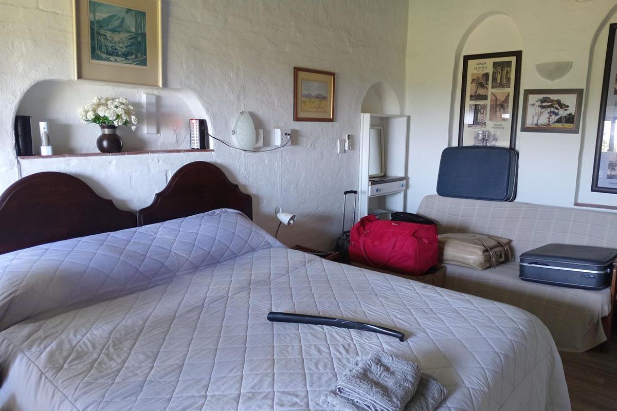 A bedroom featuring textured white walls with built-in arched wall niches and a neutral color palette.