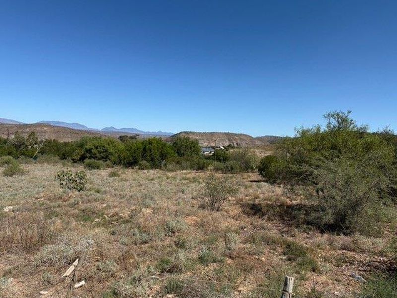 A scenic view of the natural landscape and distant mountain range, showcasing the open terrain of the vacant residential land.