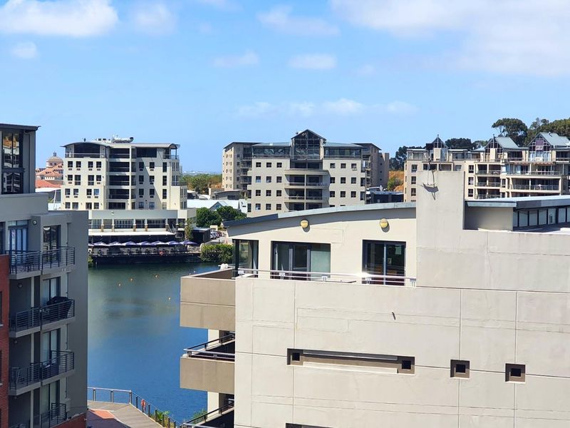 An elevated view overlooking a nearby water body and surrounding apartment buildings in a residential complex.