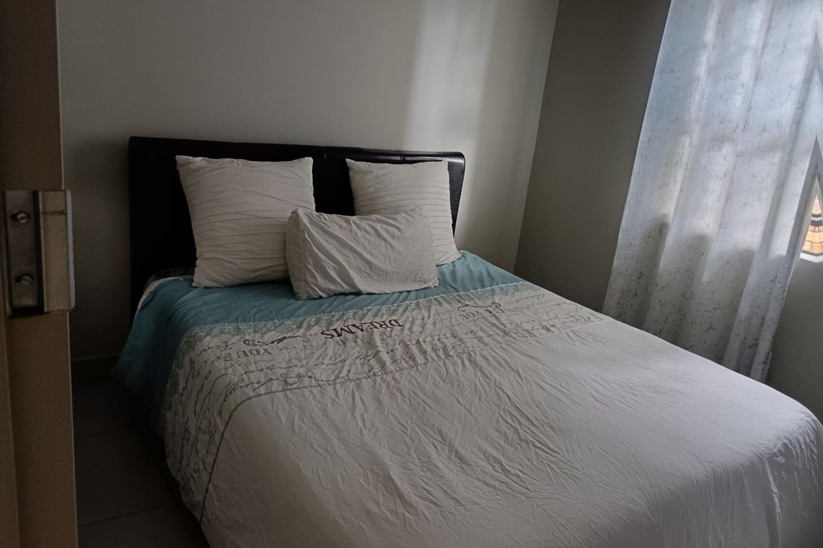 A standard bedroom featuring tiled flooring and neutral wall finishes, providing a functional space for rest.