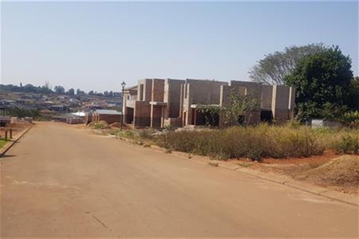 A view of a residential development site showing a partially constructed building structure in an early phase of development.