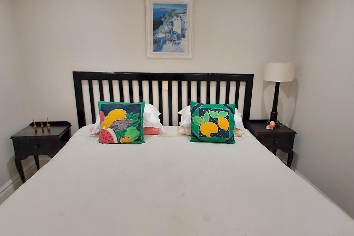 A neutrally painted bedroom featuring a simple layout, suitable for a comfortable sleeping space.