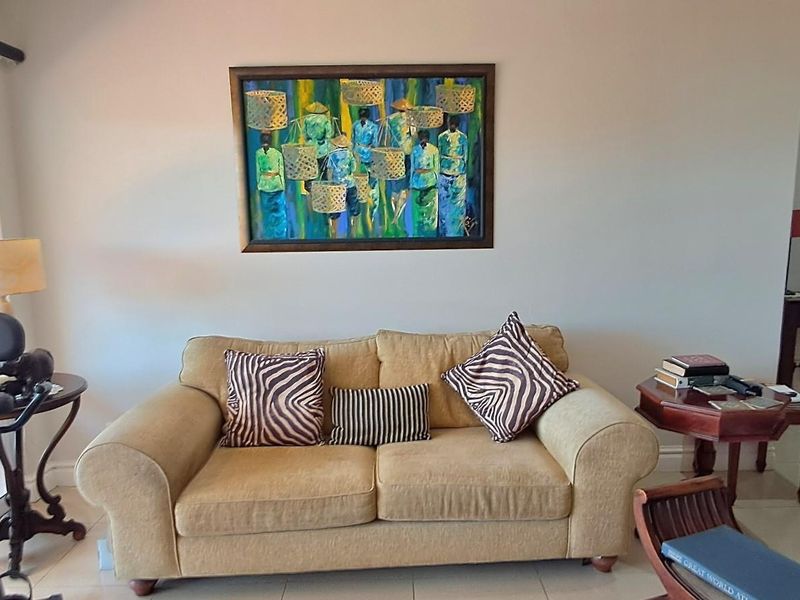 A bright living room area featuring tiled flooring and large sliding glass doors that provide access to an outdoor patio space.
