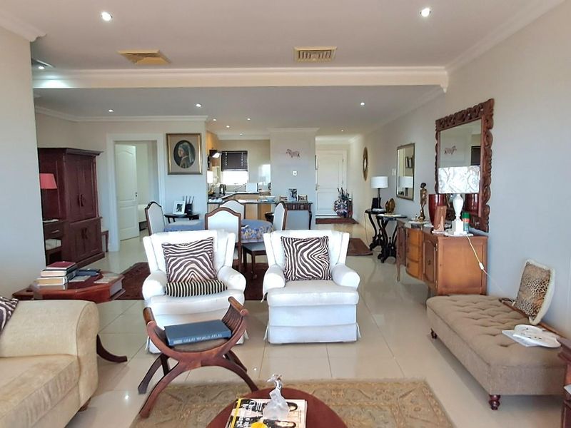 Spacious open-plan living and dining area featuring tiled flooring, recessed downlighting, and a seamless flow into the kitchen space.