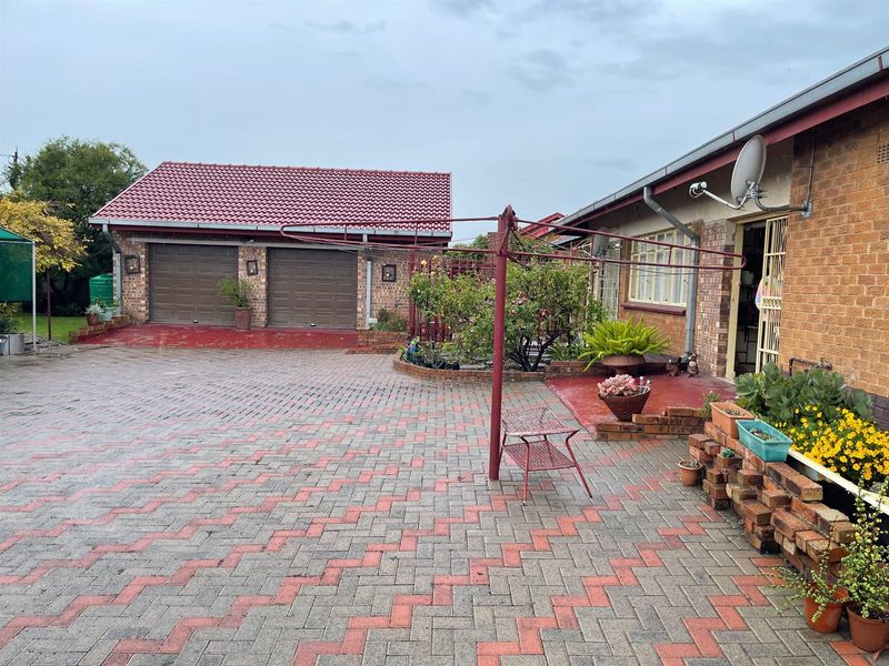 Spacious paved courtyard area featuring a double garage with tiled roof and direct access to the main dwelling.