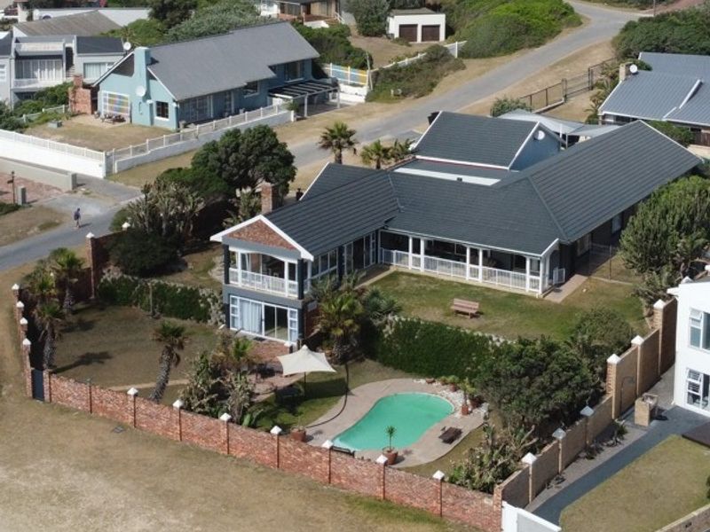 Aerial view of a residential property featuring a tiled roof, wrap-around balcony, swimming pool, and enclosed garden area with brick perimeter walling.
