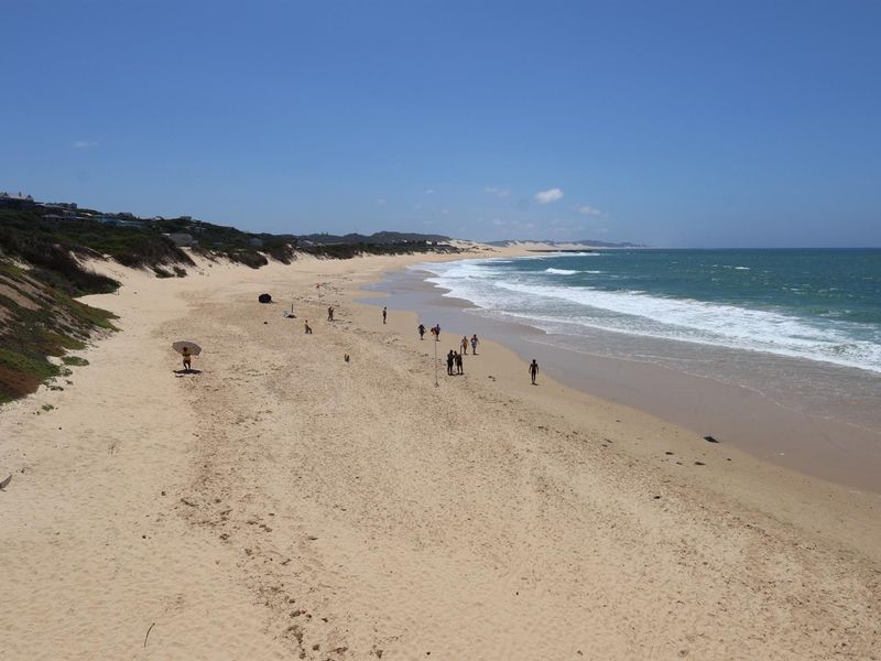 A scenic view of the sandy beach and coastline, highlighting the property's proximity to the ocean and natural surroundings.