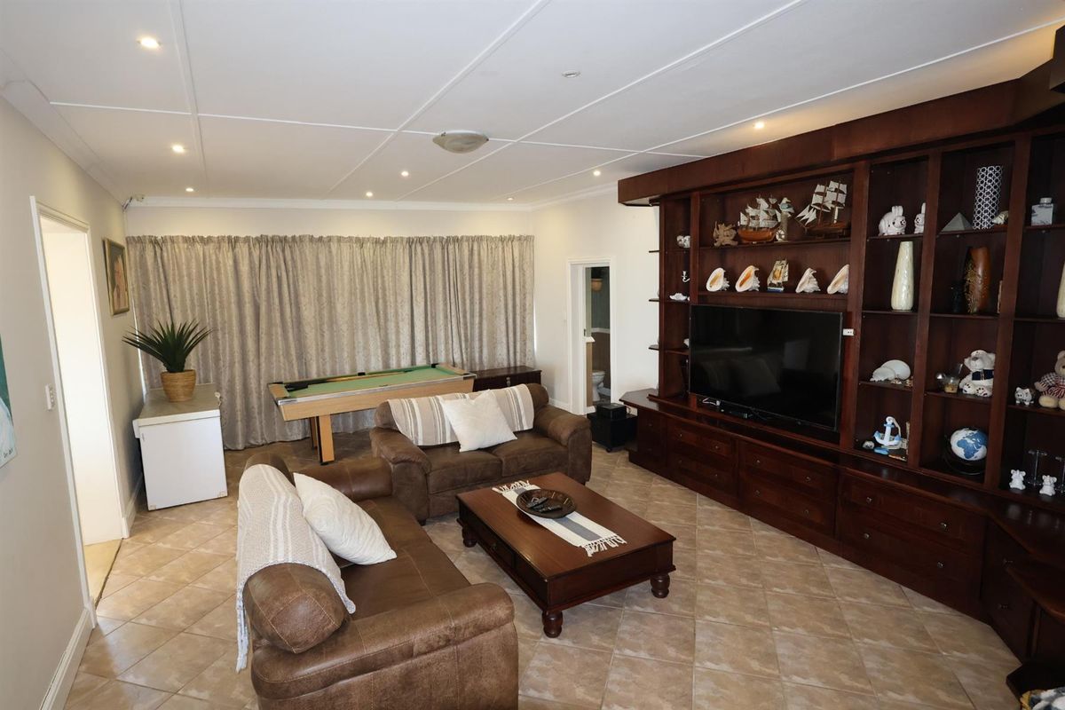 Spacious living room featuring built-in dark wood cabinetry, tiled flooring, and recessed ceiling lighting.